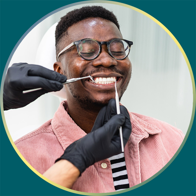 Man getting teeth checked by dental technician