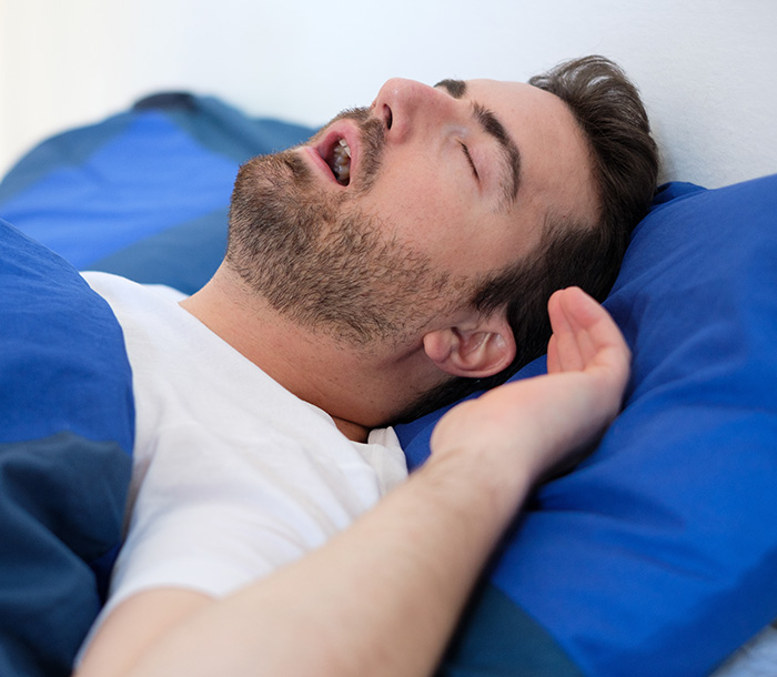 Man in bed suffering for sleep apnea syndrome