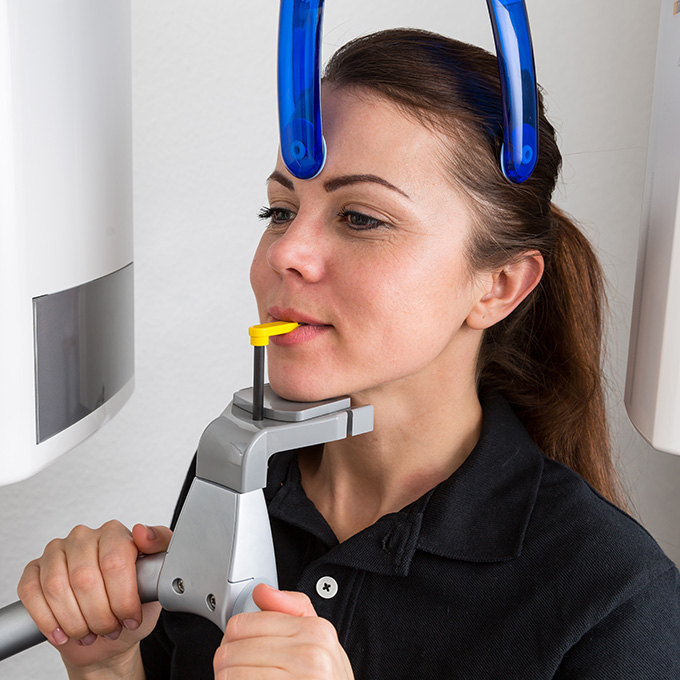 Patient in dentist's panoramic and cephalometric x-ray system